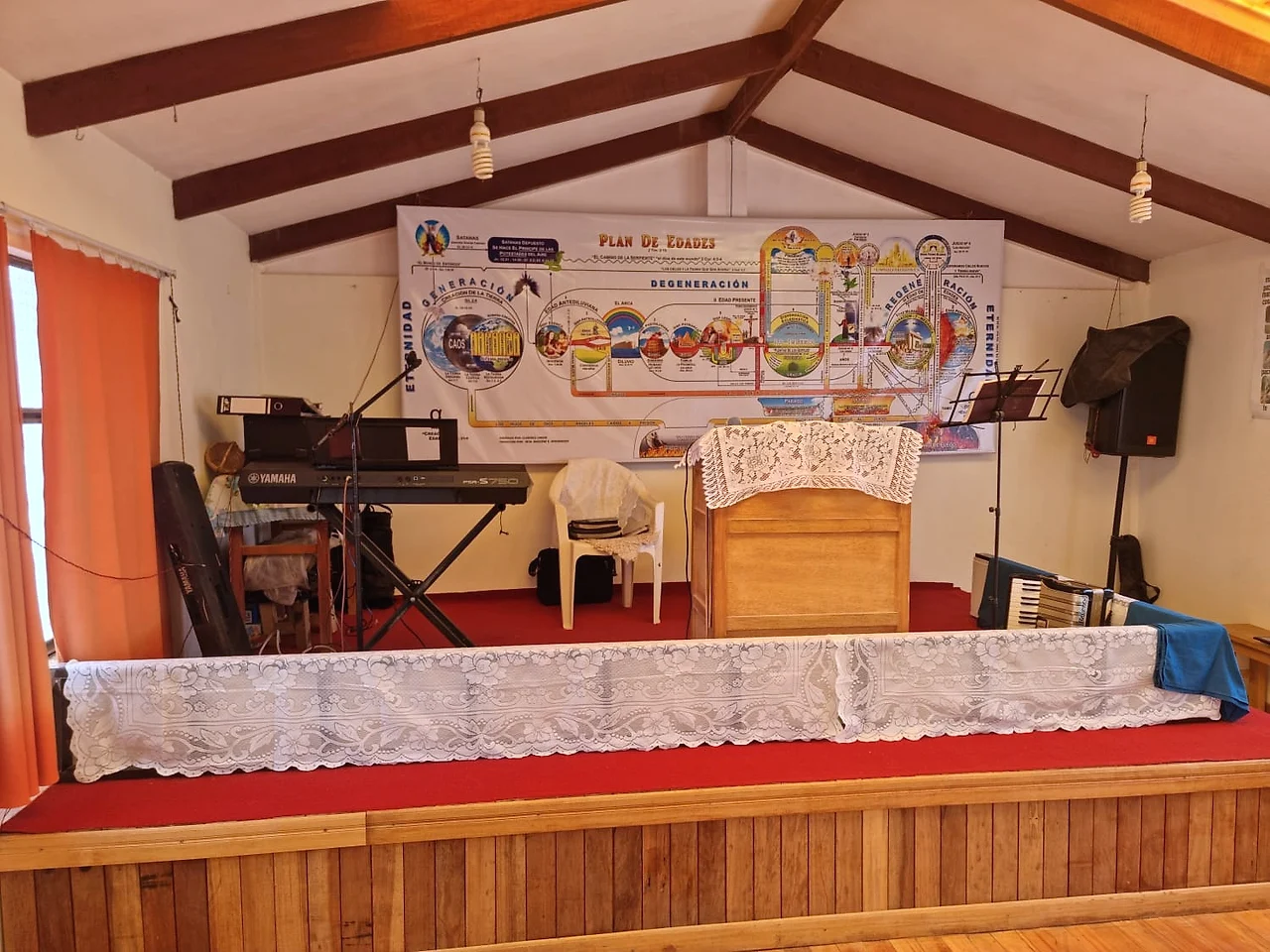 Interior del templo: el púlpito de madera, el teclado y el cuadro del plan de edades
